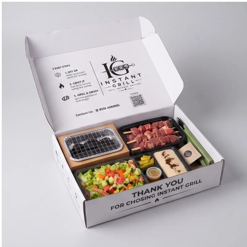 Open Instant Grill box with skewers on the built-in grill and glowing coals