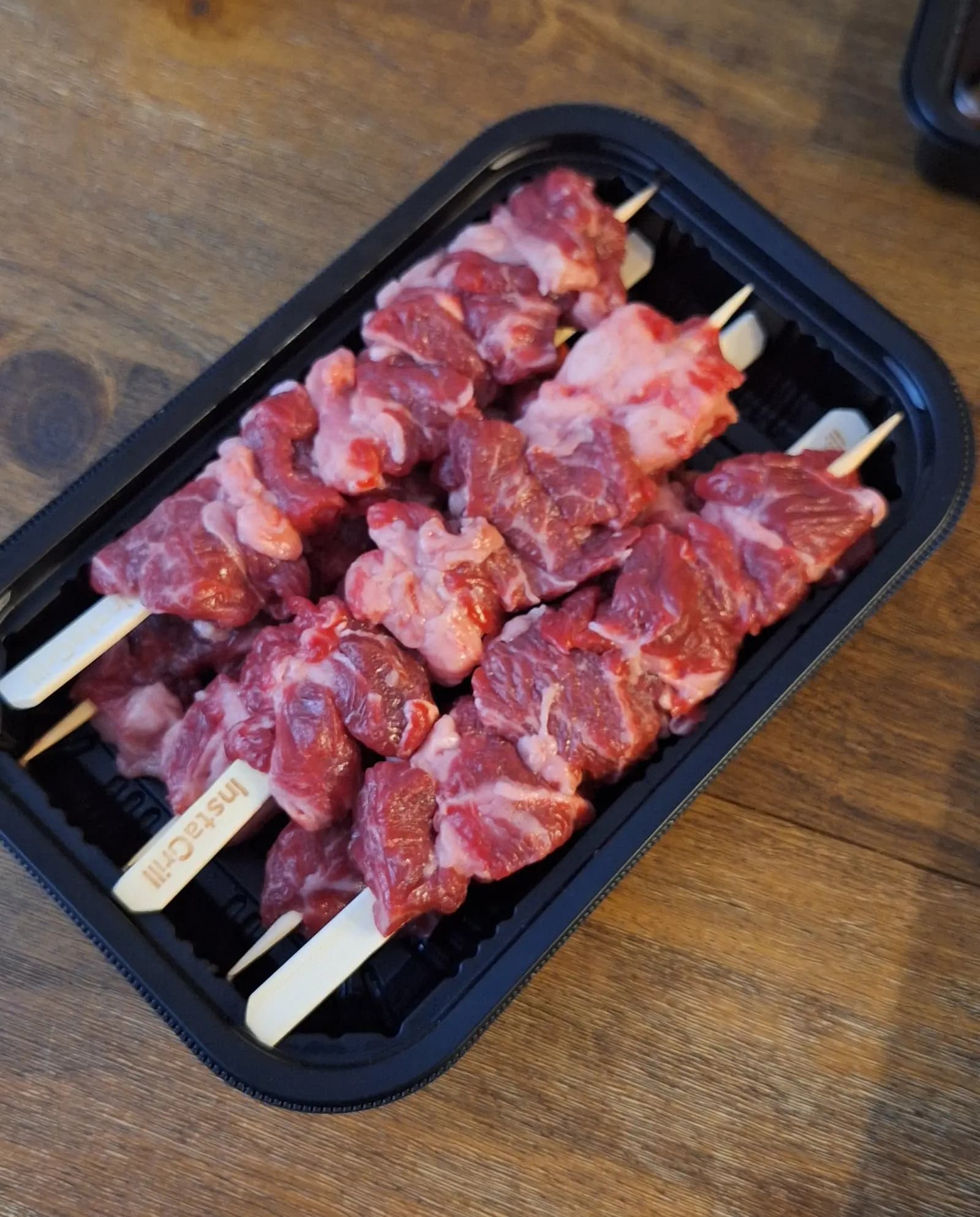 Open Instant Grill box with rib eye tikka on the grill